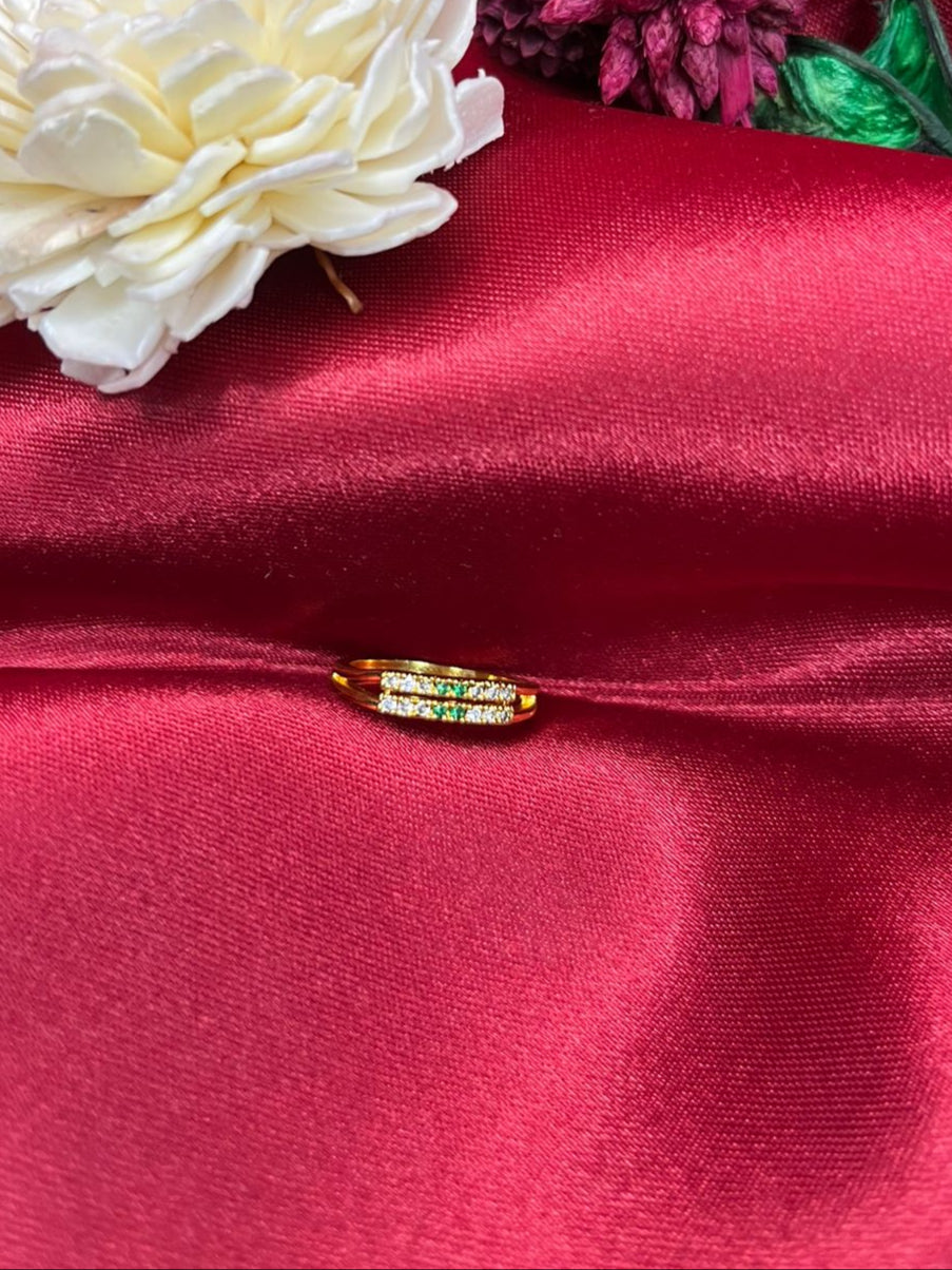 White flower, pink flower, and small decorative item on red fabric