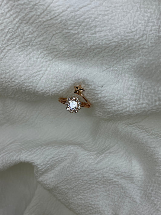 Rose gold ring with a diamond on a textured white surface