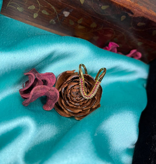Gold ring on a pine cone with a wooden box in the background